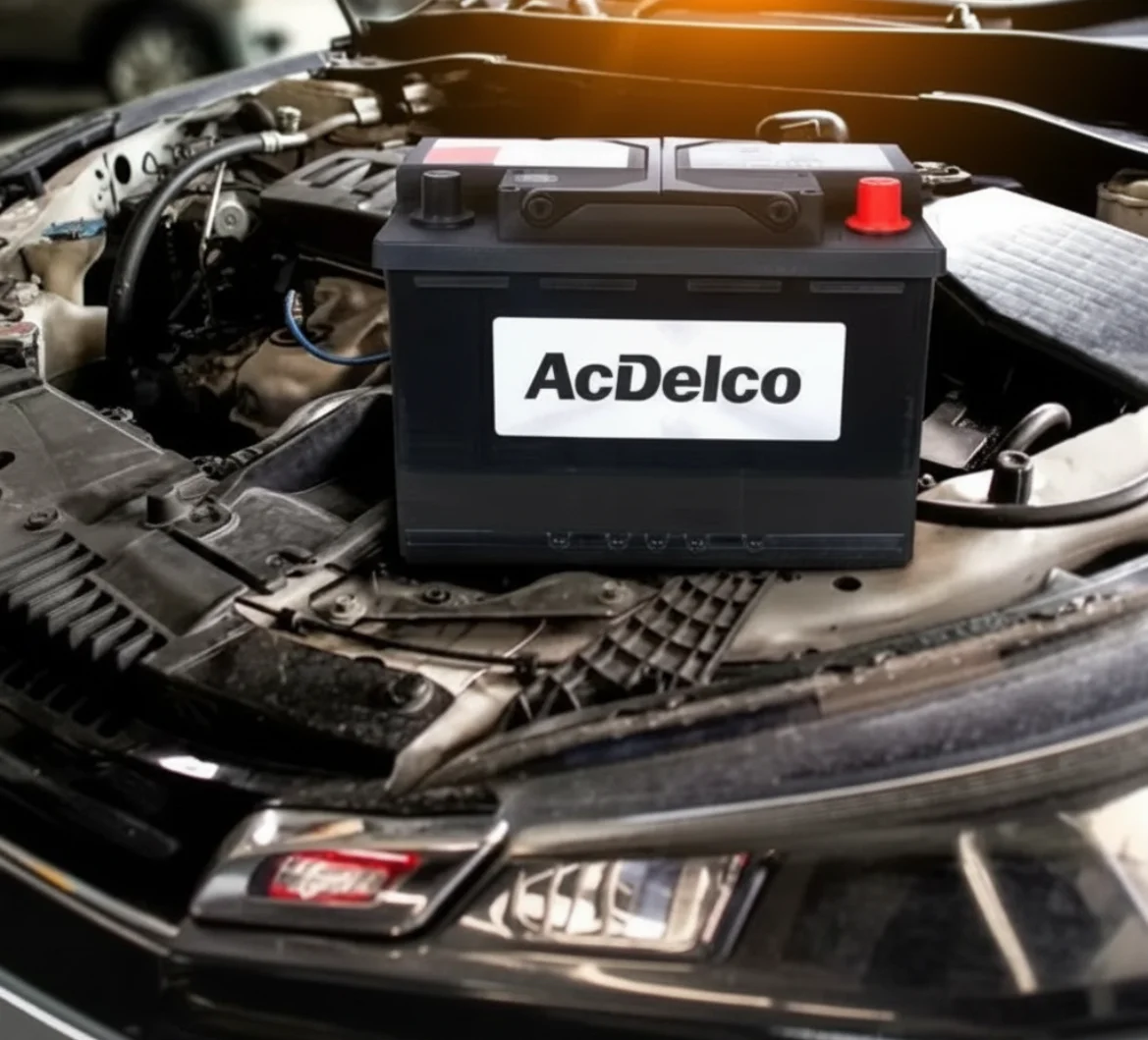 ACDelco battery sitting in an engine bay under warm light