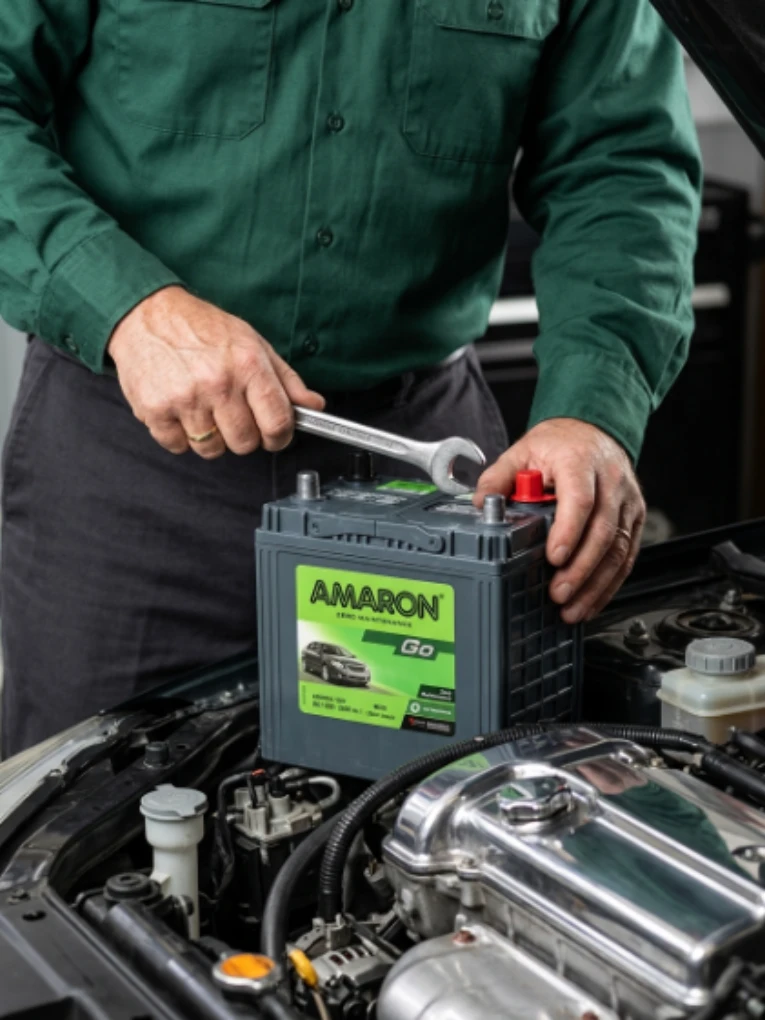 Technician in uniform tightening the terminal of an Amaron battery